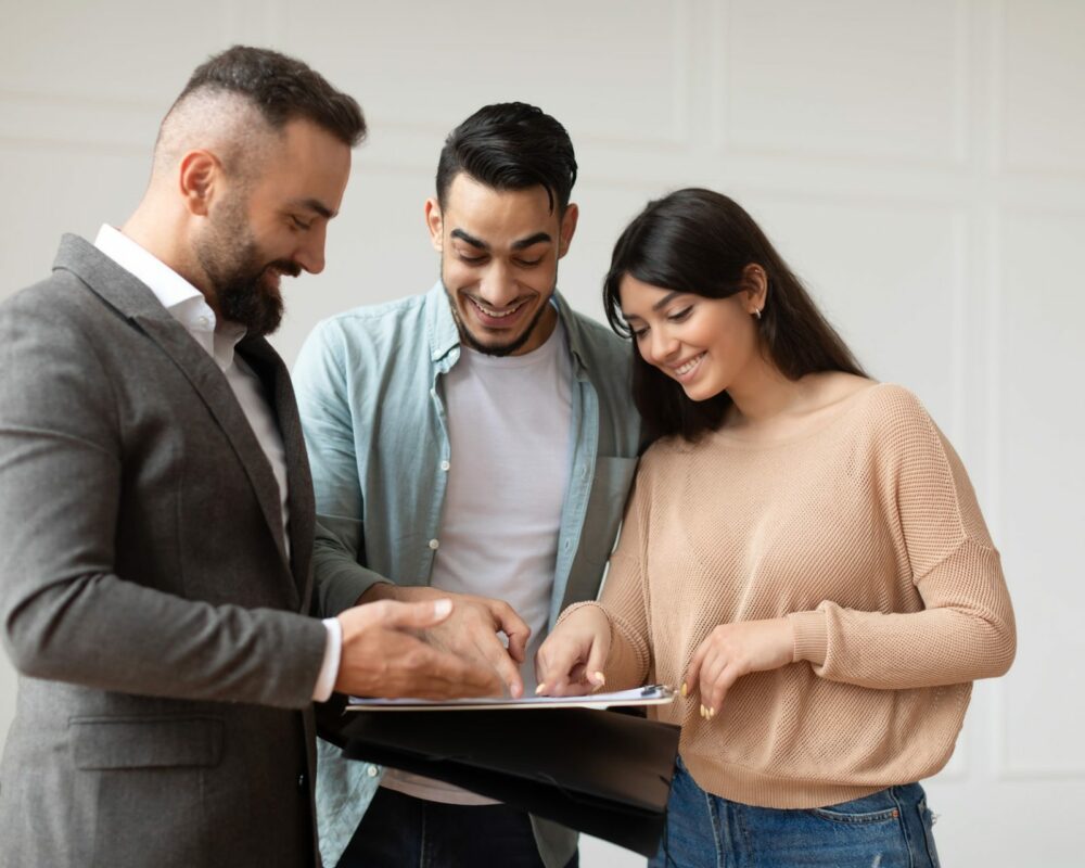 couple buying new apartment house agent showing documents blueprints.jpg